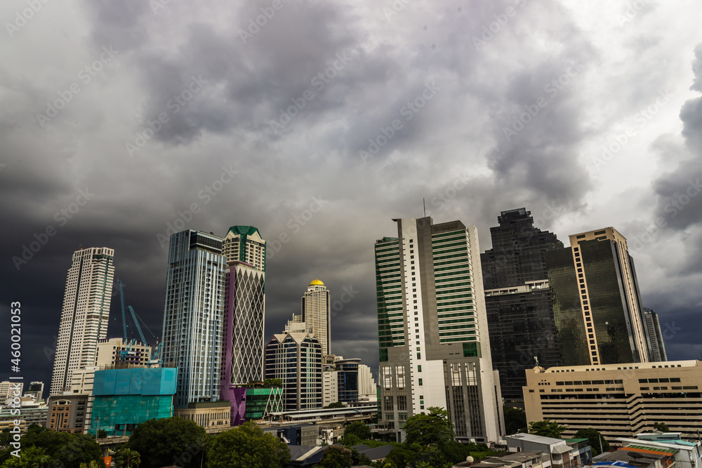 Bangkok, Thailand - Aug 13, 2020 : Dark storm clouds before rain of Bangkok city with district office building and center for business in the evening. Selective focus.