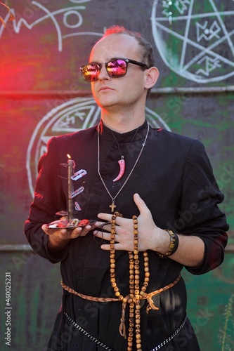 A man dressed as a priest. Halloween image. Вlack magic.
