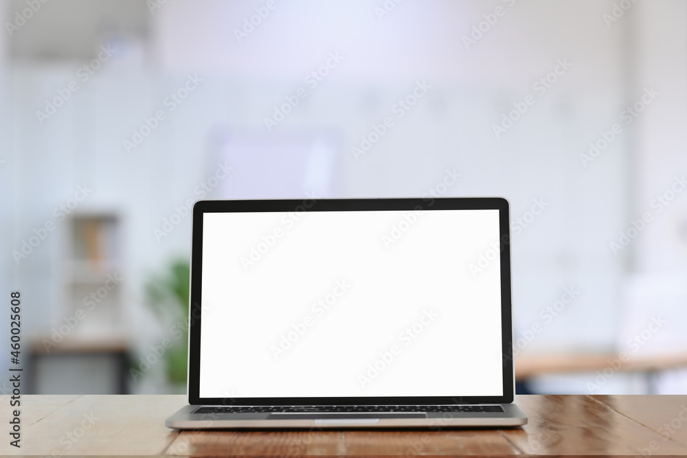 Computer laptop with white screen on wooden table in office. Computer laptop with white screen on wooden table in office.