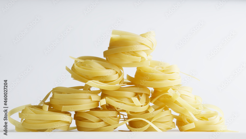 Durum wheat fettuccine pasta is laid out on a white plate in the shape of a house made of children's cubes. Daylight Durum wheat fettuccine pasta is laid out on a white plate in the shape of a house made of children's cubes. Daylight