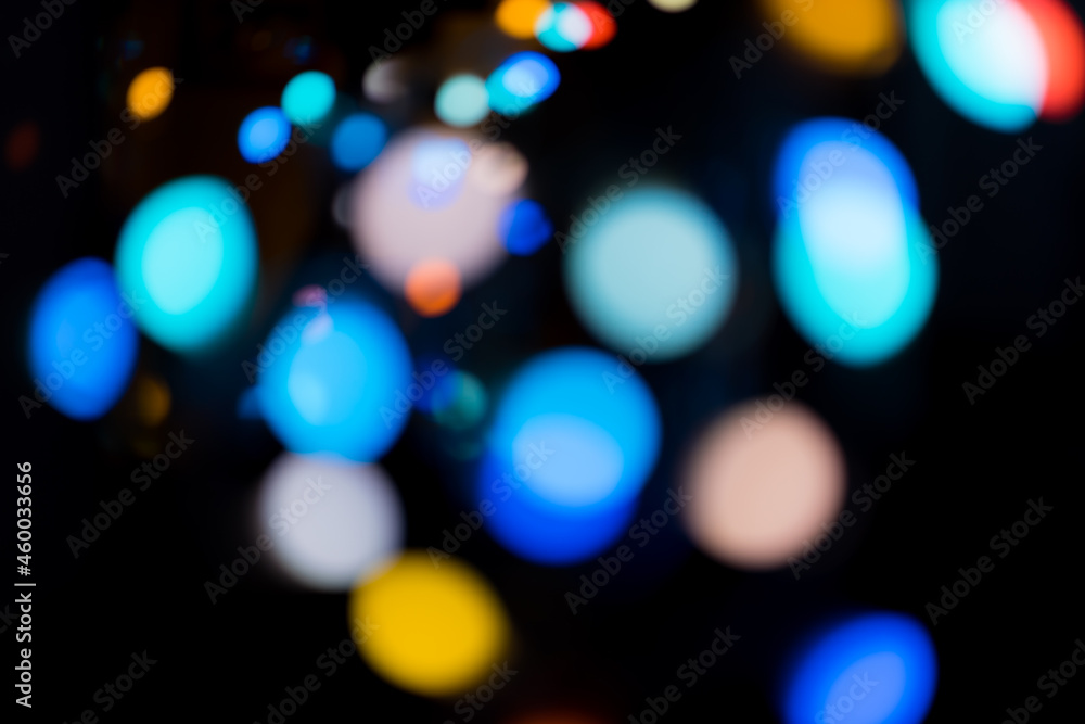 Blur multicoloured defocused glowing bokeh lights of garland on dark background Blur multicoloured defocused glowing bokeh lights of garland on dark background