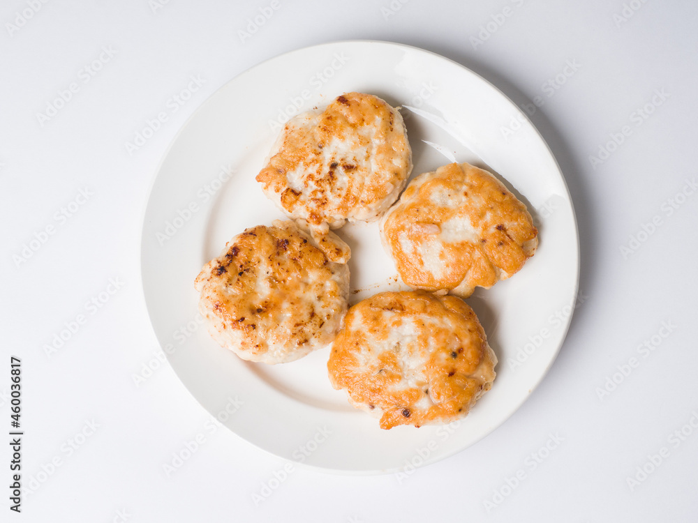 Cutlets in a white plate on a white background. View from above