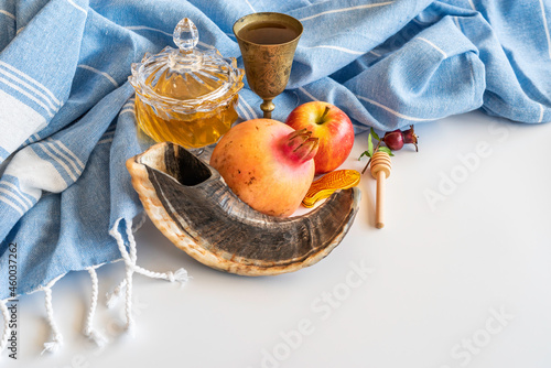 Shofar, honey, pomegranate, apple, goblet, cotton fabric on white background for Jewish holiday Rosh Hashanah.