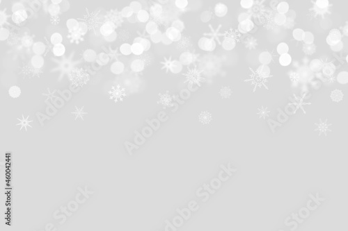 snowflakes on a light gray background with bokeh and place for text. Christmas and New Year pattern. Backdrop for postcards