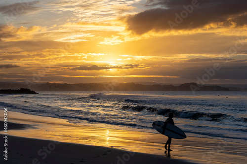 Unidentified surfers silohuettes on Coolangatta Beach in Queensland with a dramatic sunset