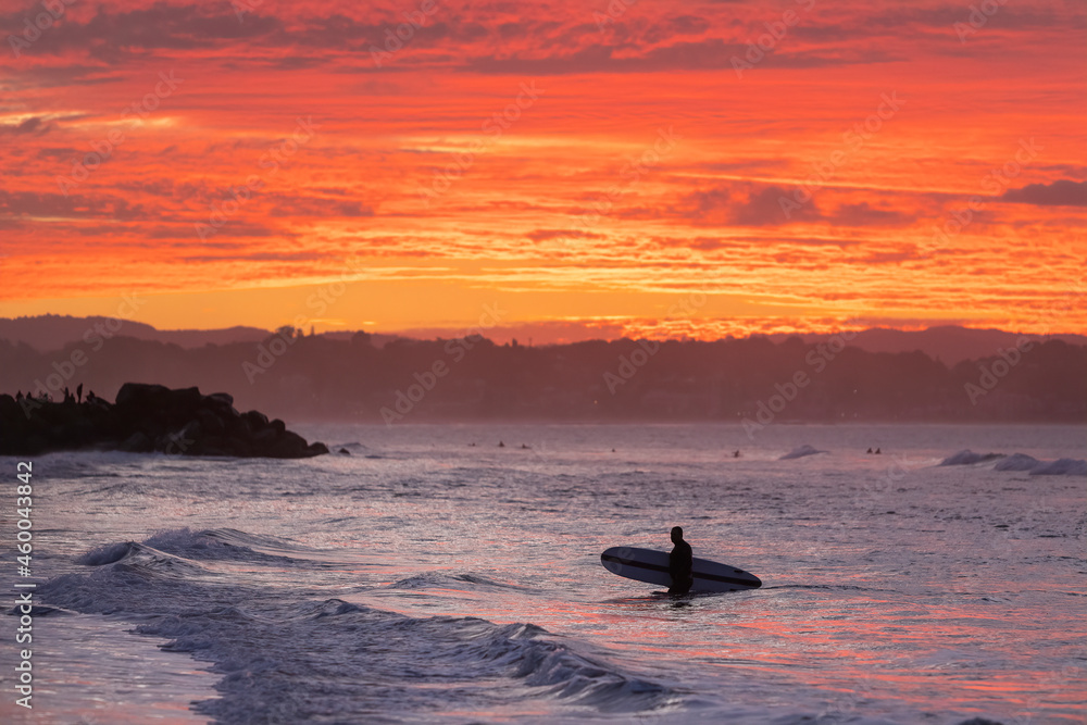 Fototapeta premium Unidentified surfers silohuettes on Coolangatta Beach in Queensland with a dramatic sunset