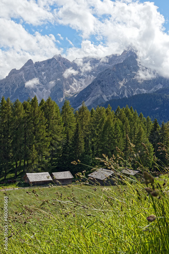 Hüttendorf auf einer Bergwiese mit den Gipfeln der Sextner Dolomiten im Hintergrund, Pustertal, Alpen, Südtirol, Italien 