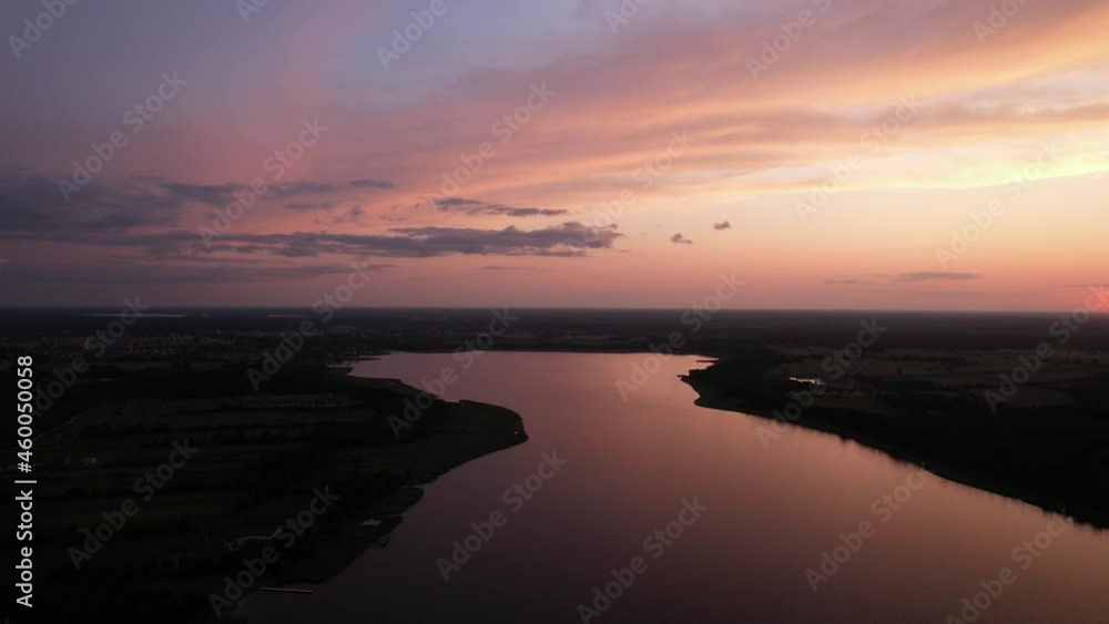 Beautiful sunset over the lake. Bird's eye view of the lake and the marina. Clouds on orange sky during summer sundown. Slow flight over the water. Beautiful sunset over the lake. Bird's eye view of the lake and the marina. Clouds on orange sky during summer sundown. Slow flight over the water.