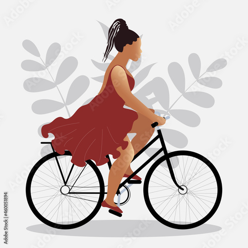 An attractive woman in a dress fluttering in the wind rides a bicycle. Happy and healthy body concept. The girl goes in for sports and mental health. 
