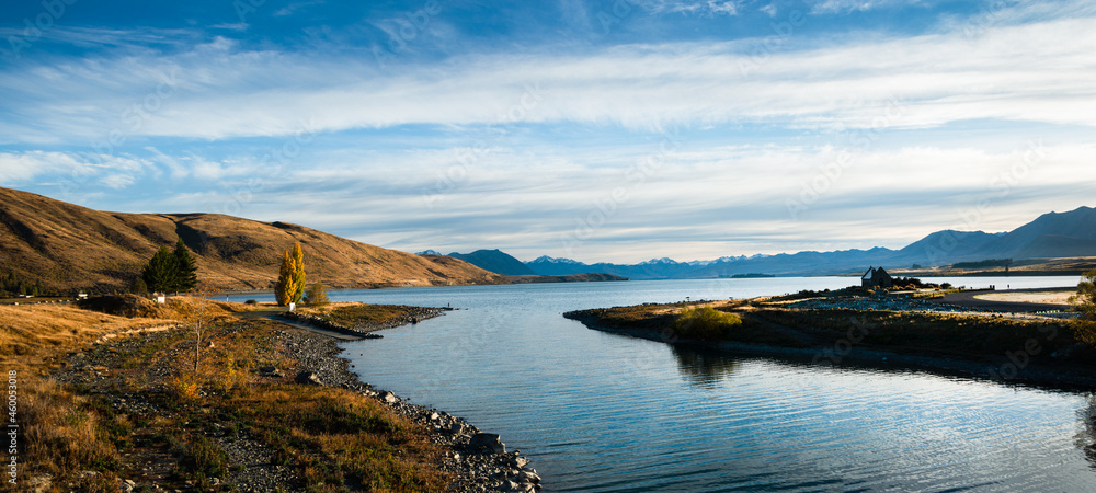 Obraz premium Panorama view of Lake Tekapo in autumn with Church of the Good Shepherd at right and Southern Alps in the background, Mackenzie country, South Island.