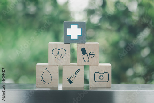 Icon healthcare medical on wooden blocks stacked in a pyramid shape on a nature background. Medical and pharmaceutical concept