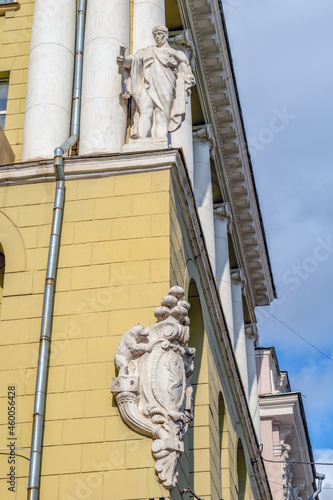 Kharkiv, Ukraine - October 20, 2020: Decoration with sculptures of the facade of an old residential building at 17 Sumska Street in Kharkiv. Male statue and stone coat of arms on the wall of the house