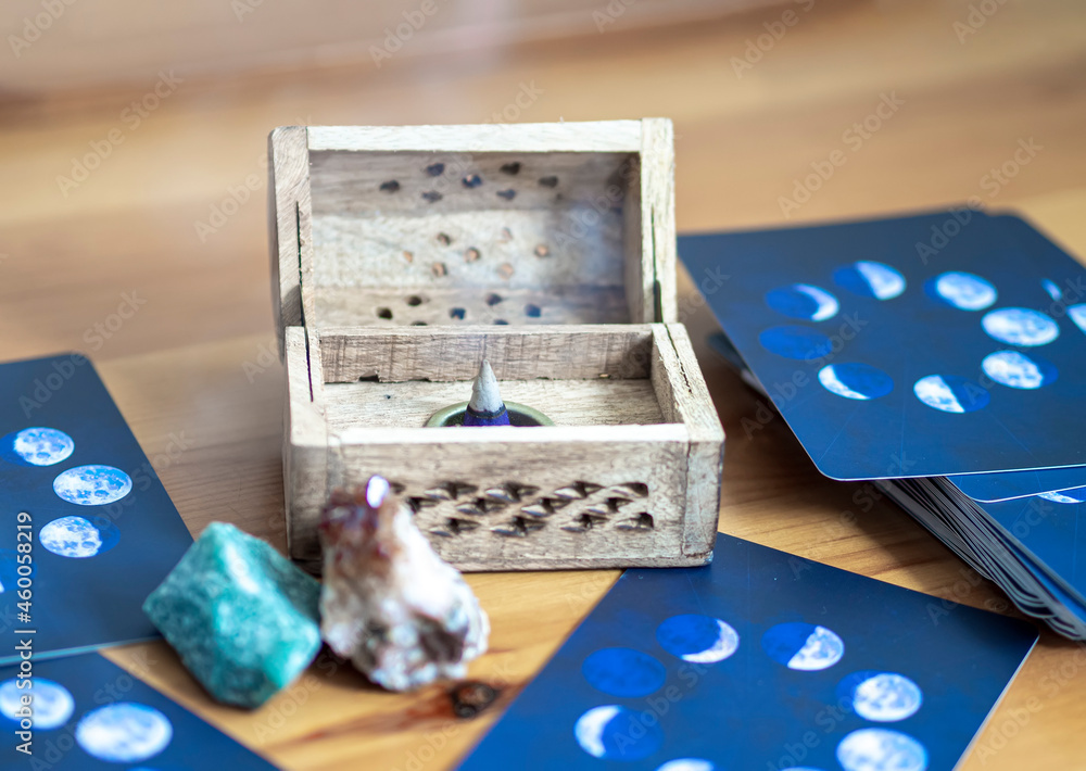 Close up of an incense cone light up with magical crystals and tarot cards deck. Divination and