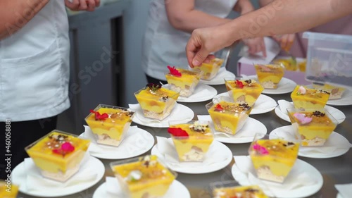 Catering. the waiter puts on the table kremenki with dessert and decorates.  photo