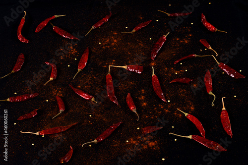 Pile crushed red pepper, Cayenne pepper, dried chili flakes isolated on black background