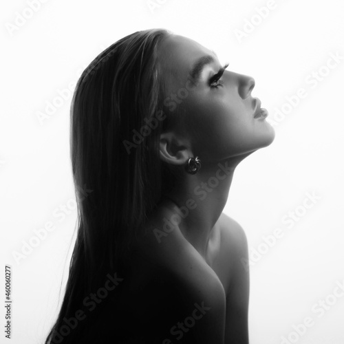 Black and white fashion creative make up. Beautiful portrait of young woman with clean fresh skin and bright make up posing on a bright blue background