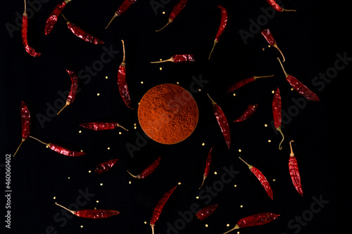 Pile crushed red pepper, Cayenne pepper, dried chili flakes isolated on black background