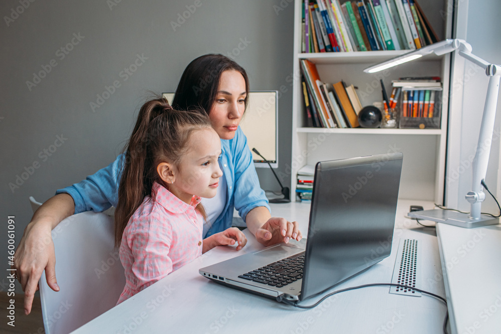 mom helps daughter do homework remotely on laptop mom helps daughter do homework remotely on laptop