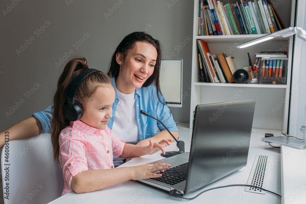 mom helps daughter do homework remotely on laptop mom helps daughter do homework remotely on laptop