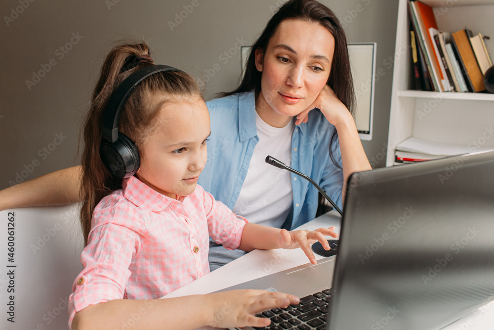 mom helps daughter do homework remotely on laptop mom helps daughter do homework remotely on laptop