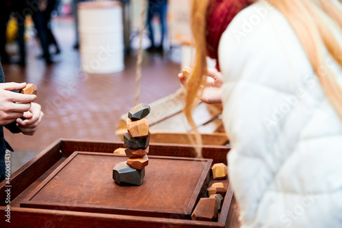 People fold pebbles of different shapes in the form of a turret on a wooden board, the game