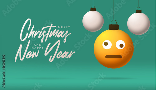Merry Christmas card with Dizzy confused smile emoji face. Vector illustration in flat style with Xmas lettering and emotion in christmas ball hang on thread on background