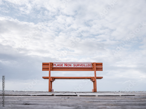 un banc public avec écrit dessus plage non surveillée