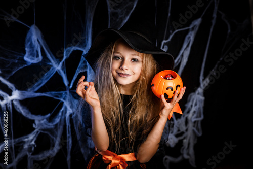 Little girl in witch costume having fun on Halloween trick or treat. Halloween witch