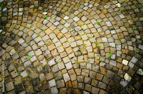 Stone cobblestone pattern in warm tones with texture on the floor of a street in the Swiss city of Zug.