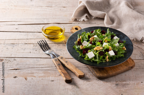 Beetroot salad with feta cheese,lettuce and walnuts on rustic wooden table.Copy space