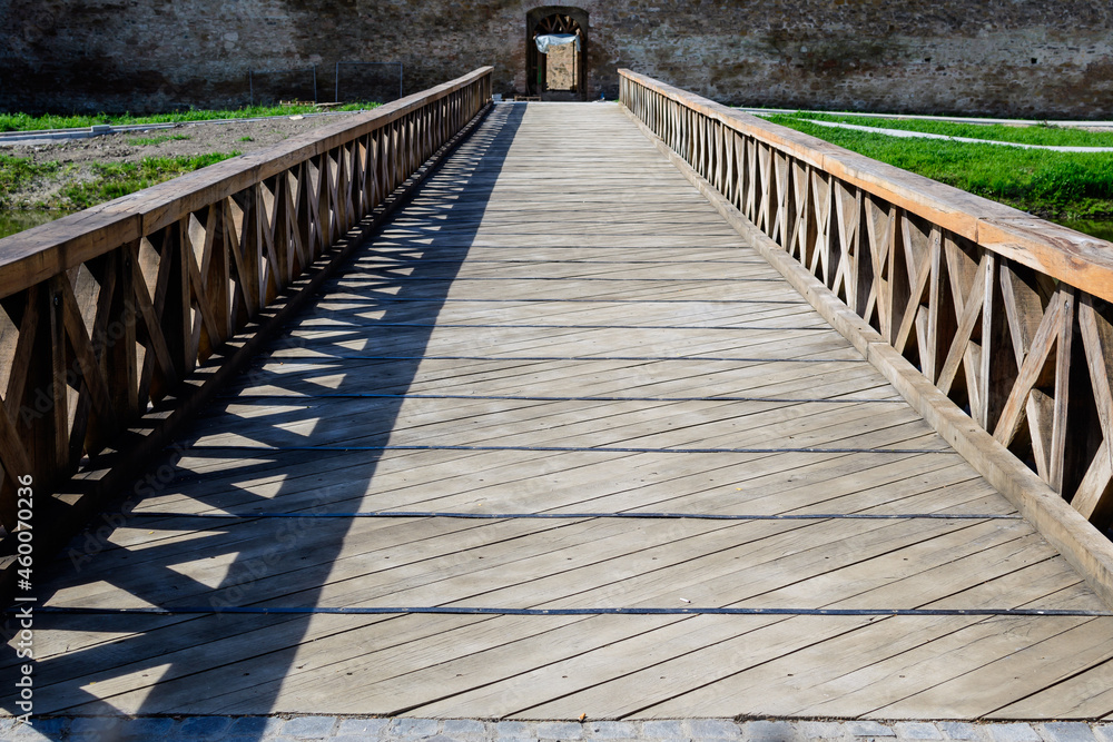 Large wooden bridge at the entry into the historical buildings of Fagaras Fortress (Cetatea Fagaras) in a sunny summer day, in Transylvania (Transilvania) region, Romania  .