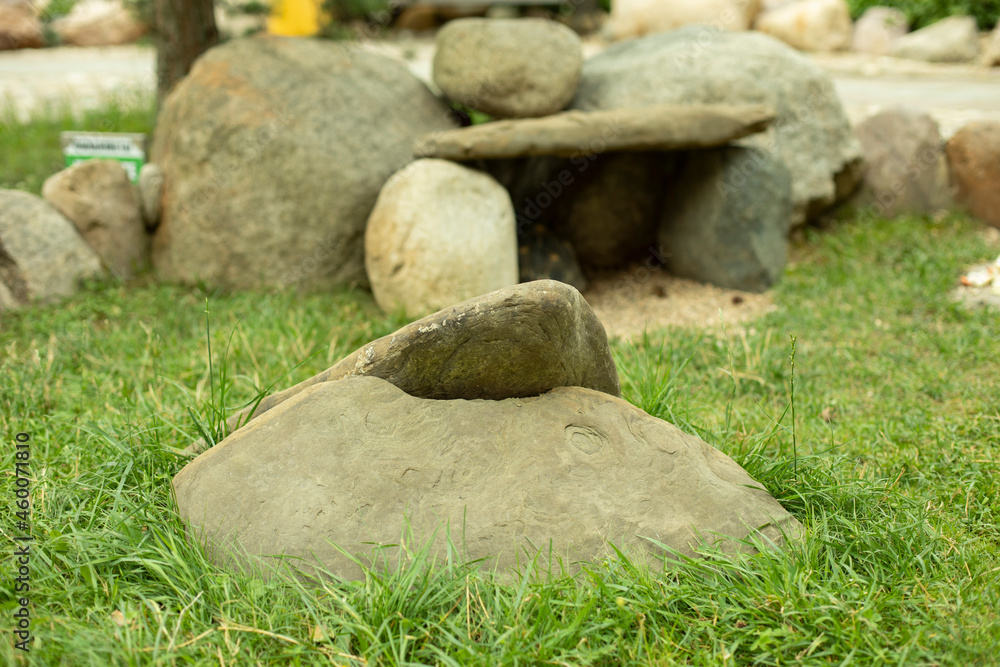 A house made of stones for a turtle in the park. The stones are stacked together on the grass. A house made of stones for a turtle in the park. The stones are stacked together on the grass.