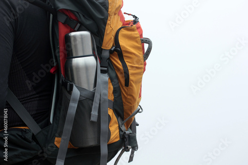 Steel thermos in the pocket of the backpack. Tourist Traveler bag. Adventure Walk.