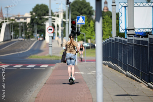 A young woman is going on a scooter 