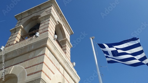 Chapel of St. George, Lycabettus hill., Athens. Detail of the bell tower and flag of Greece, against clear blue sky
