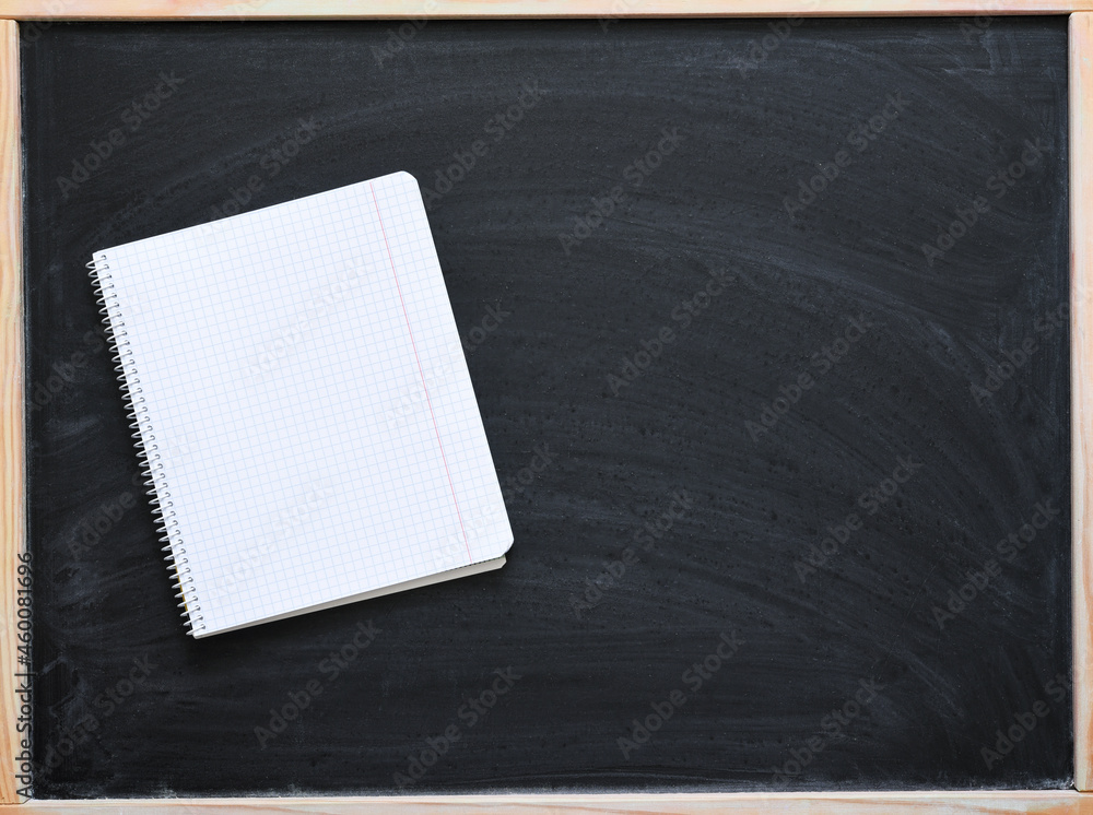 School notebook on black chalkboard. Back to school. School notebook on black chalkboard. Back to school.