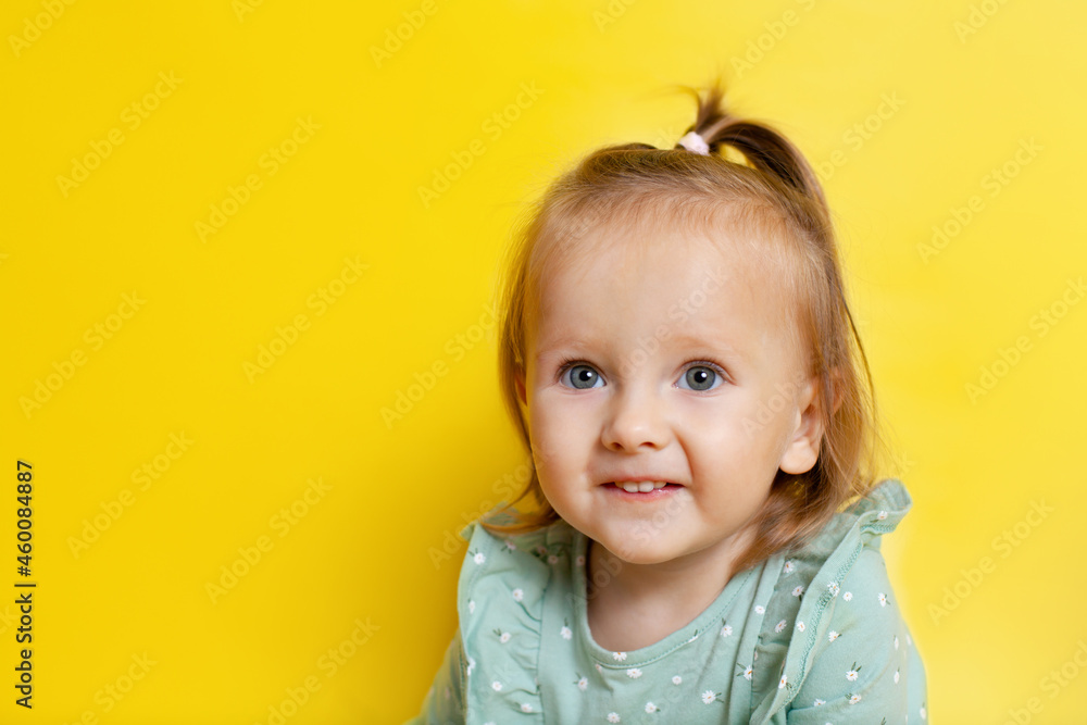 Portrait of a cute baby girl with blue eyes on a yellow background. A place for text. Portrait of a cute baby girl with blue eyes on a yellow background. A place for text.