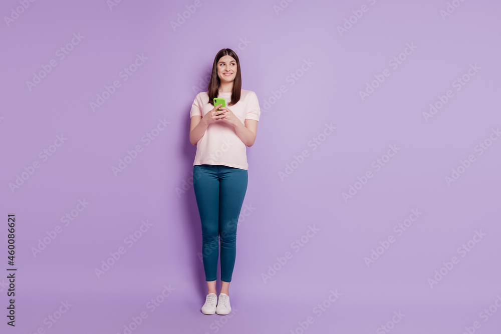 Portrait of curious interested funny blogger lady hold cellphone look empty space on violet background Portrait of curious interested funny blogger lady hold cellphone look empty space on violet background