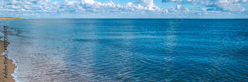 Panoramic seascape with gentle waves rolling in on the beach in the Atlantic Ocean in Massachusetts
