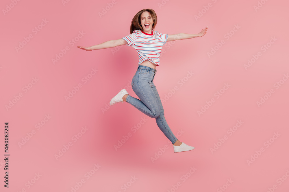 Portrait of positive dreamy lovely lady jump run posing hands wings on pink background