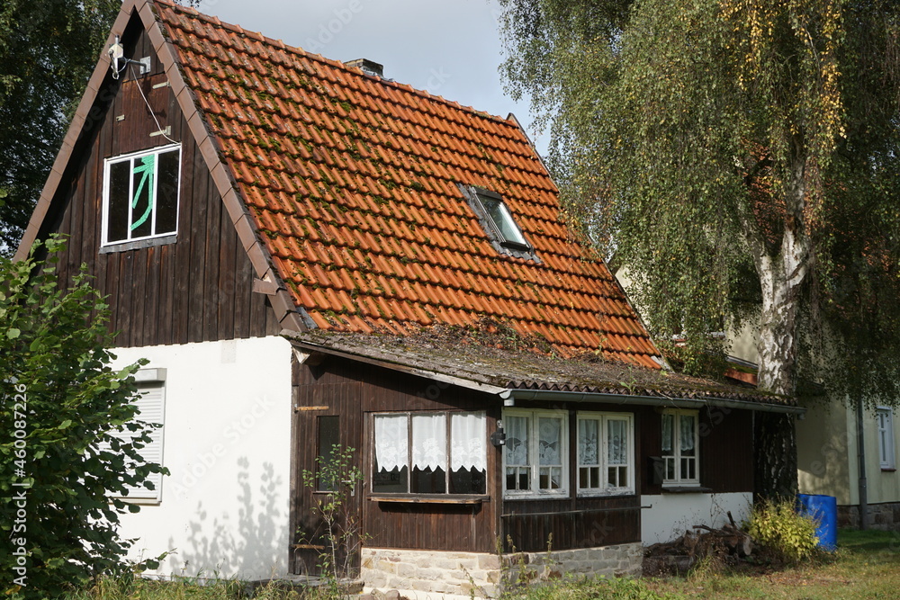 Altes Haus mit roten alten Dachziegeln und einem aus Holz