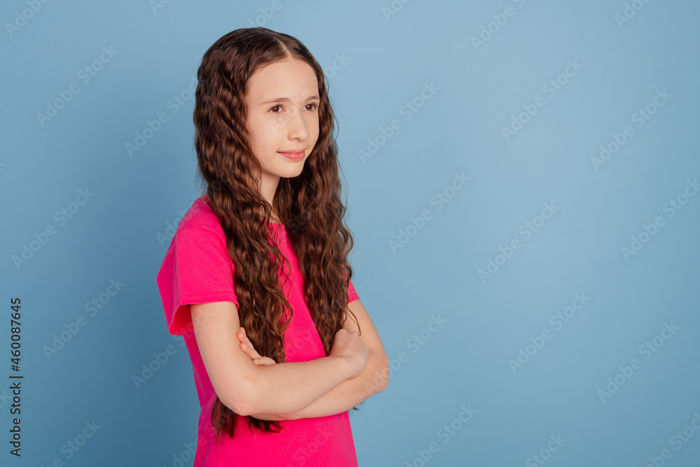 Profile portrait of lovely sweet small girl crossed hands look blank space on blue background Profile portrait of lovely sweet small girl crossed hands look blank space on blue background