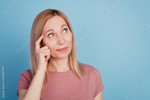Close up portrait of pretty confident thoughtful girl finger touch head think look empty space isolated over blue background