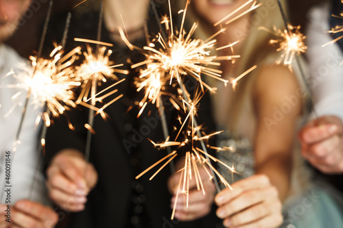 Out of focused image of people with sparklers celebrating  holiday or event photo