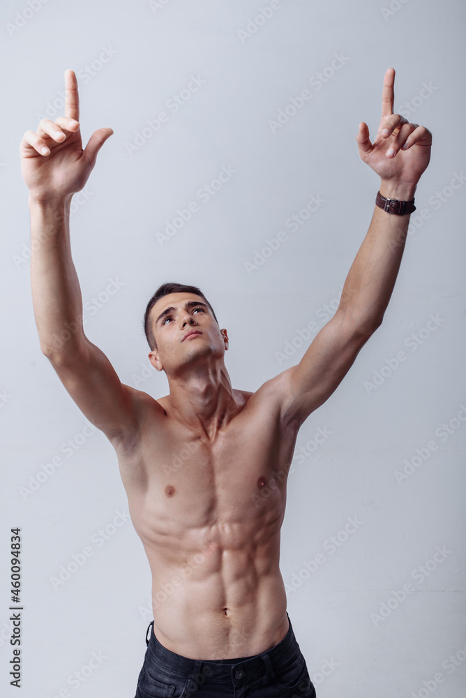 Fototapeta premium Handsome young bodybuilder showing of his fit body and muscles. Sport and healthy concept isolated on white background. Attractive fit athletic young man shirtless