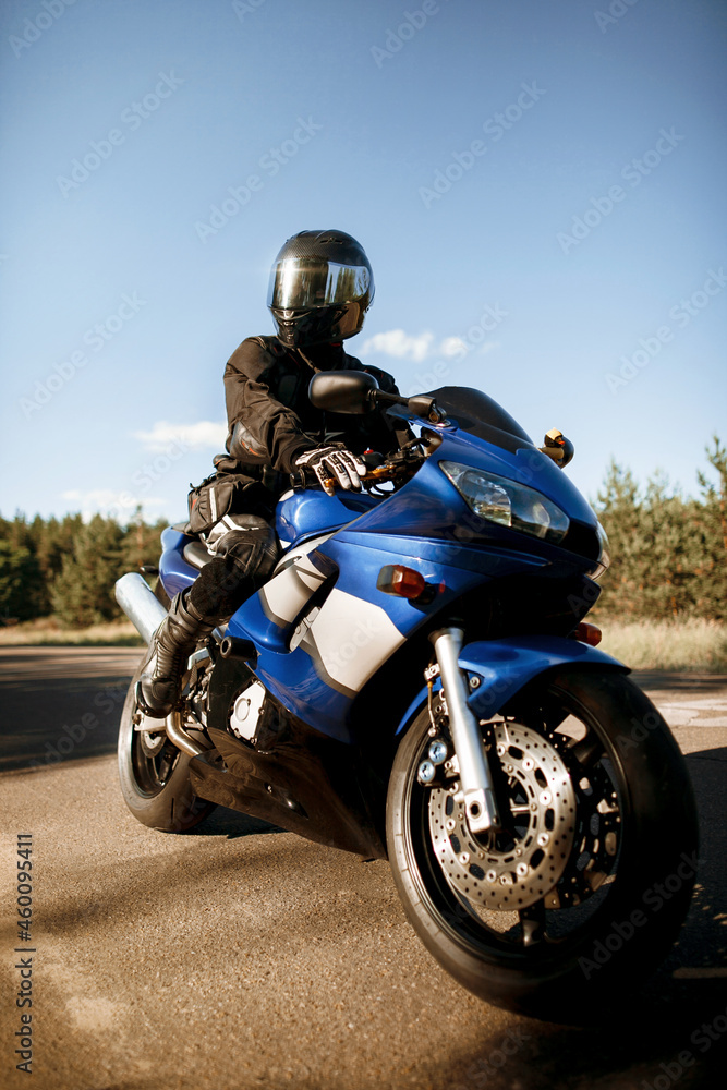 Beautiful motorcycle riding on a forest road. Have fun driving an empty road on a motorcycle ride in the warm sunbeams of the sunset. Beautiful motorcycle riding on a forest road. Have fun driving an empty road on a motorcycle ride in the warm sunbeams of the sunset.