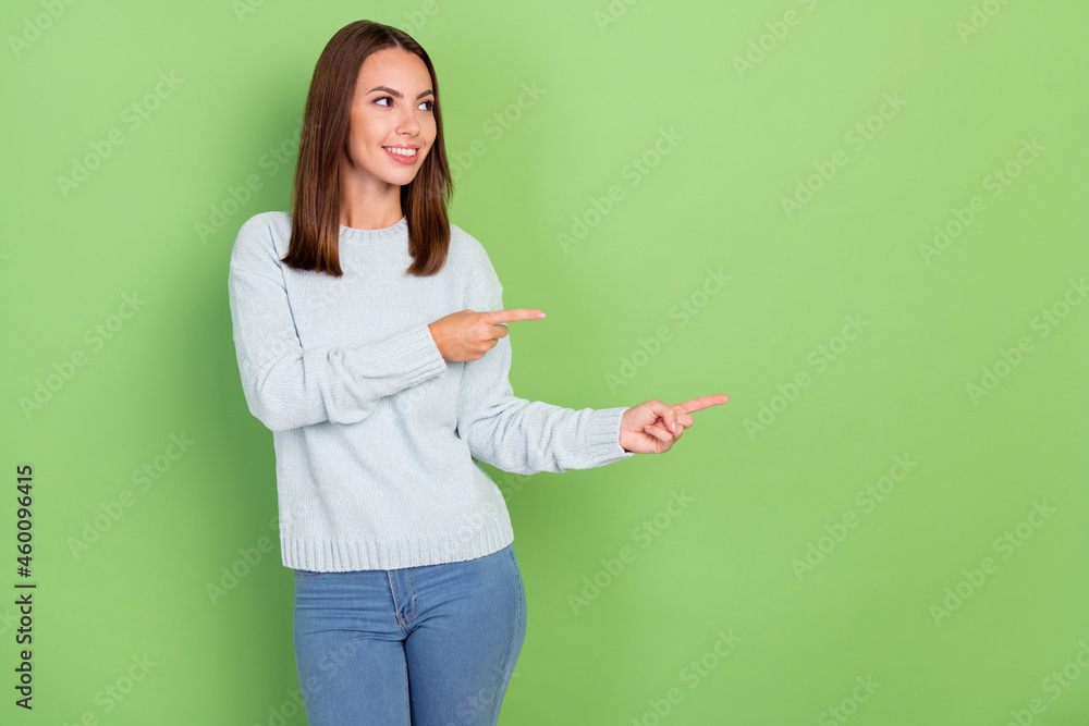 Photo of optimistic young brunette lady look point empty space isolated on green color background Photo of optimistic young brunette lady look point empty space isolated on green color background