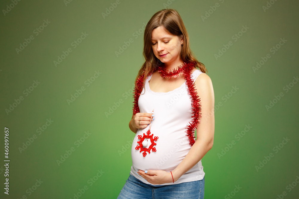 Pregnant woman with Christmas decorations, expecting baby birth on Christmas eve. How to celebrate New year's eve when you are expecting a baby. Pregnant woman with Christmas decorations, expecting baby birth on Christmas eve. How to celebrate New year's eve when you are expecting a baby.