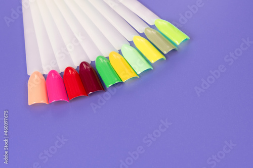 Multiсolor nail tips on a purple background. examples of manicure for nails. Palette with color samples of nail. Copy space