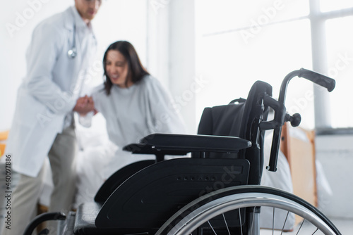 modern wheelchair near doctor with patient on blurred background